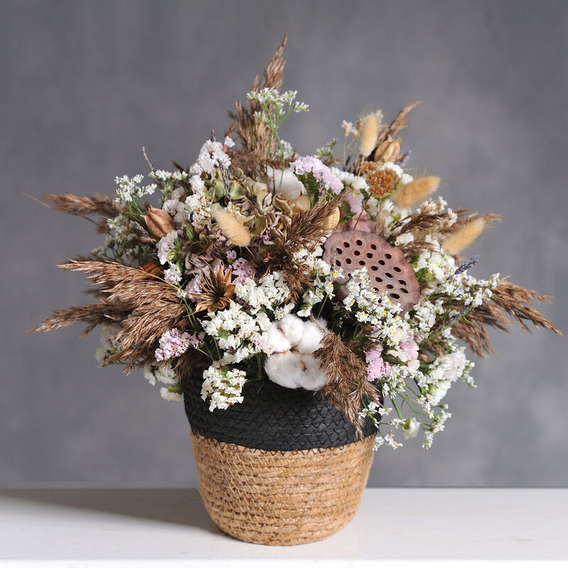 Dried flower arrangement in woven basket — pampas, cotton, statice and dried roses