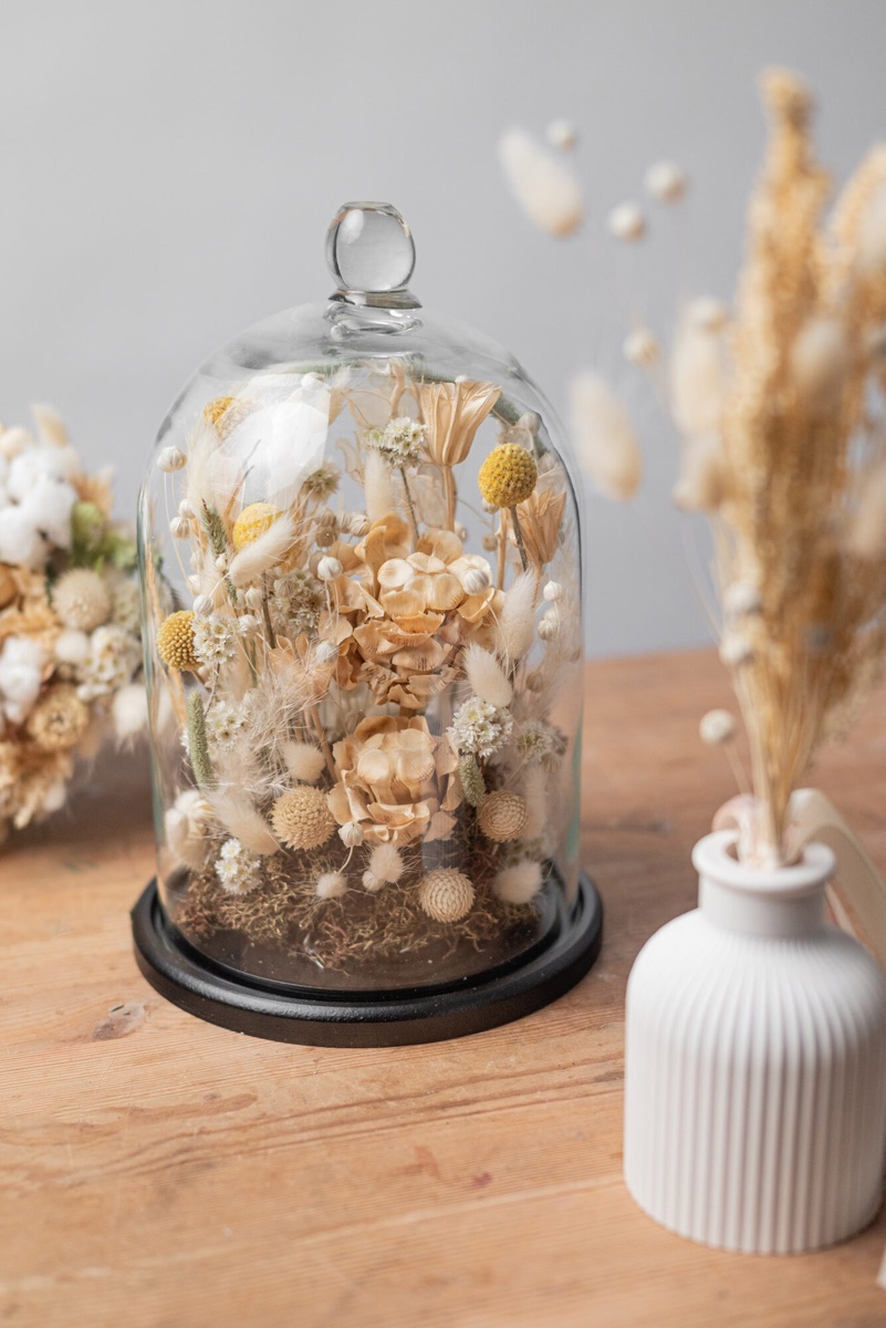 Finished dried flower bouquet with golden craspedia, pampas grass and dried berries — studio photo on neutral grey background