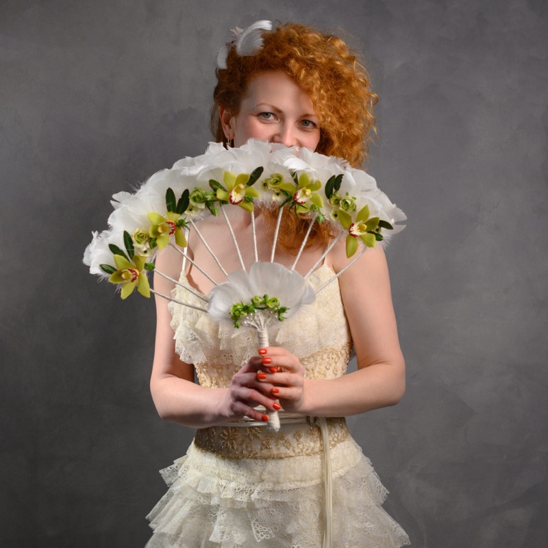 Katya, floristry instructor, holding a glass cloche dried flower arrangement