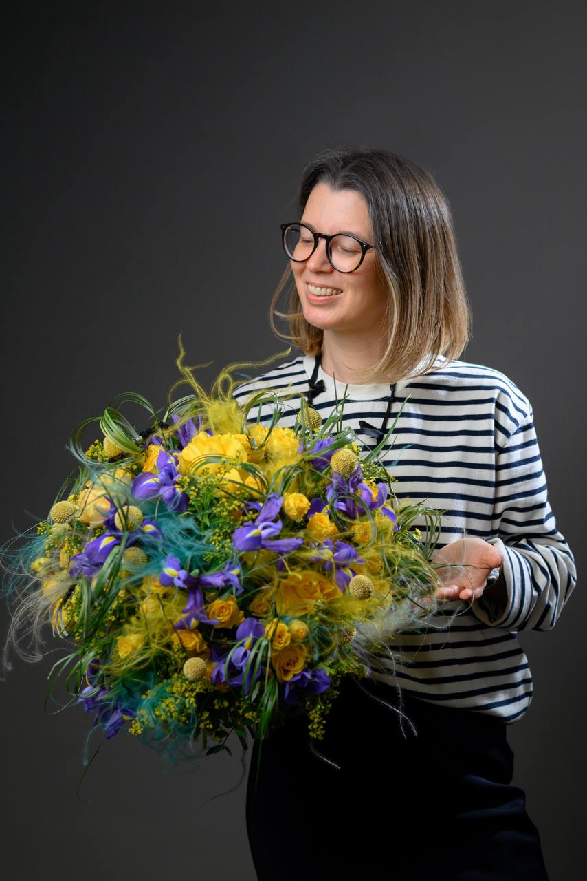 Laysan Afonina, founder of Kazan Flower School, holding a colorful bouquet